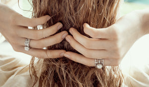 blond woman touching her hair with the two hands