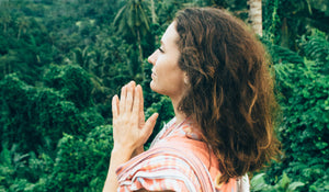 woman praying and feeling blessed in a natural environment